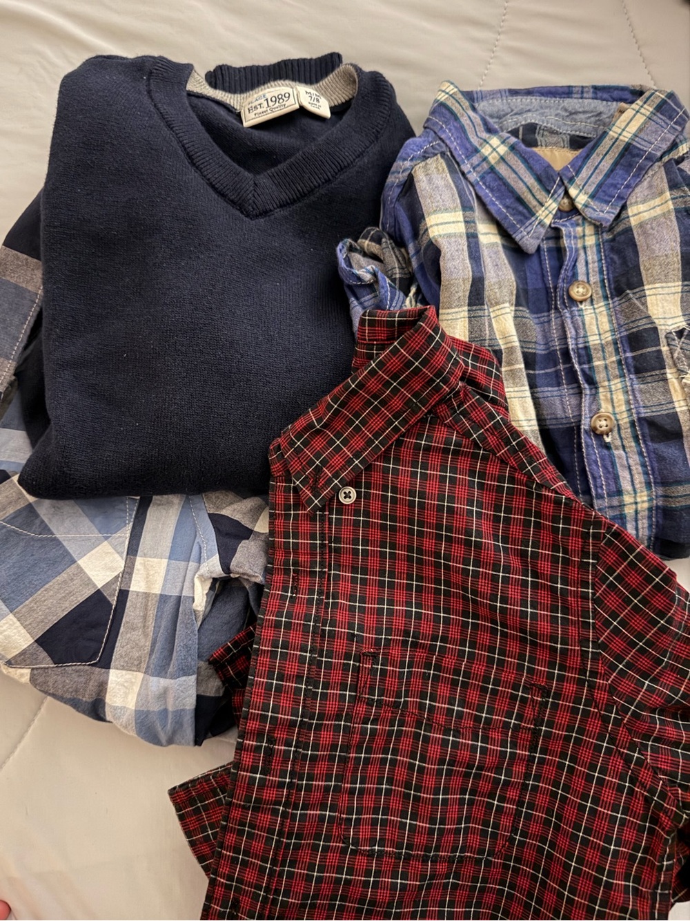 3 long sleeve button down shirts and a navy v-neck sweater